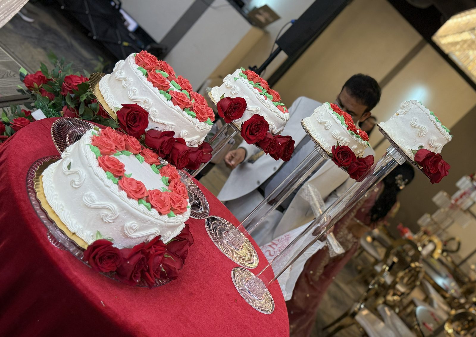 Tiered wedding cake dressed with red roses