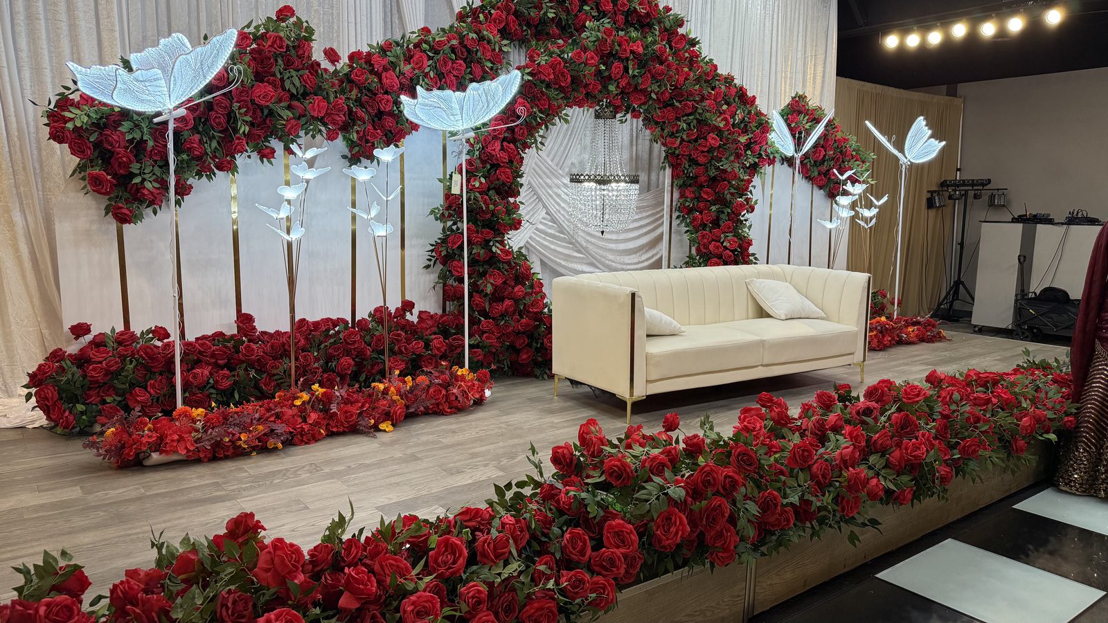 Red-rose reception stage with a cream settee